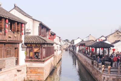 The canal between concrete buildings during the day
